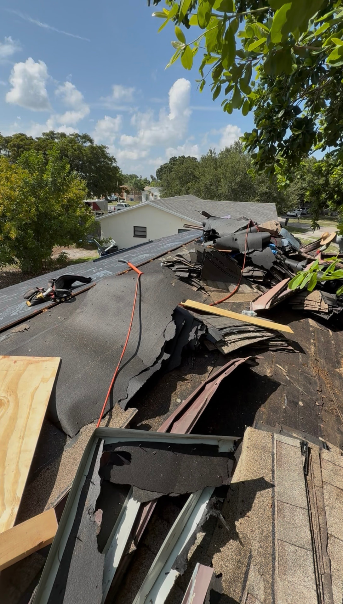 Roof tear-off in progress with old shingles removed down to the deck